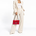 Gucci Dollar shoulder bag styled on model in ivory tailored outfit, neck-down view